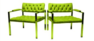 A pair of empty green, comfortable chairs sit next to each other.