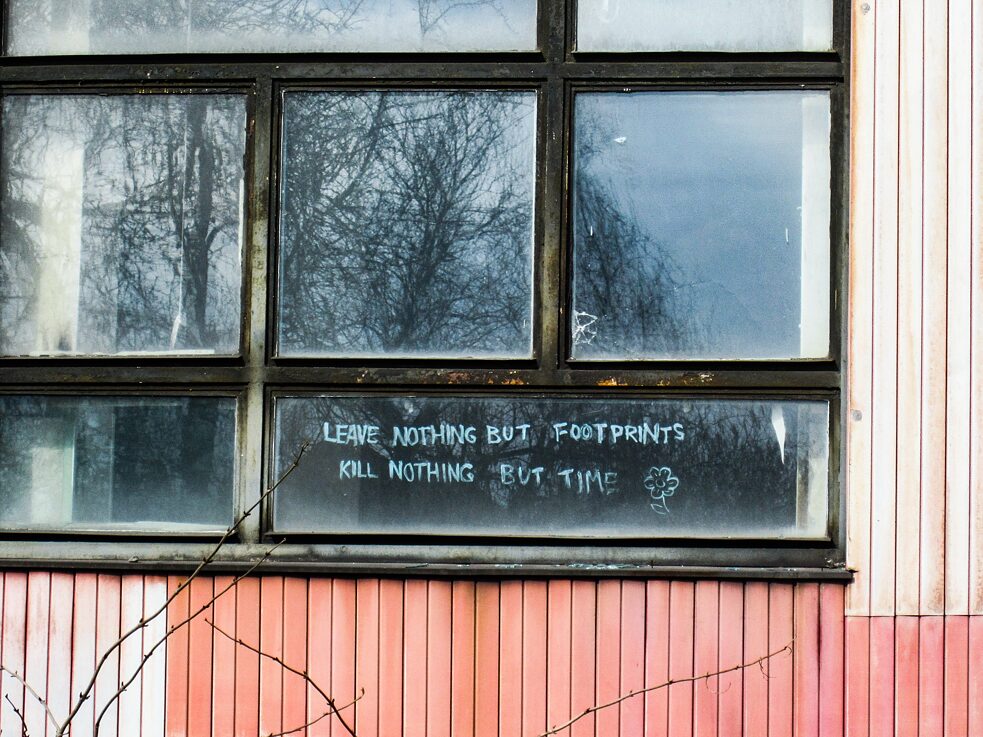 Alte Fensterfront mit Schriftzug auf einer Scheibe.