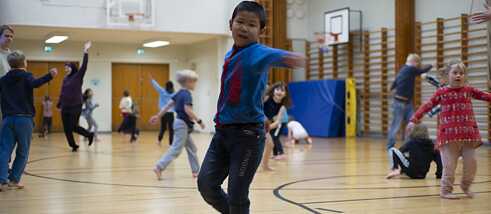 Tanzende Kinder in einer Turnhalle