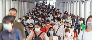 A crowd of people with masks during rush hour on March 18, 2020 in Bangkok, Thailand