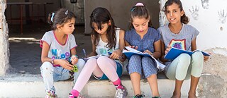 Children sit on stairs in the Lagadikia refugee camp, about 40 km north of Thessaloniki, during a visit by the UN High Commissioner for Refugees Filippo Grandi