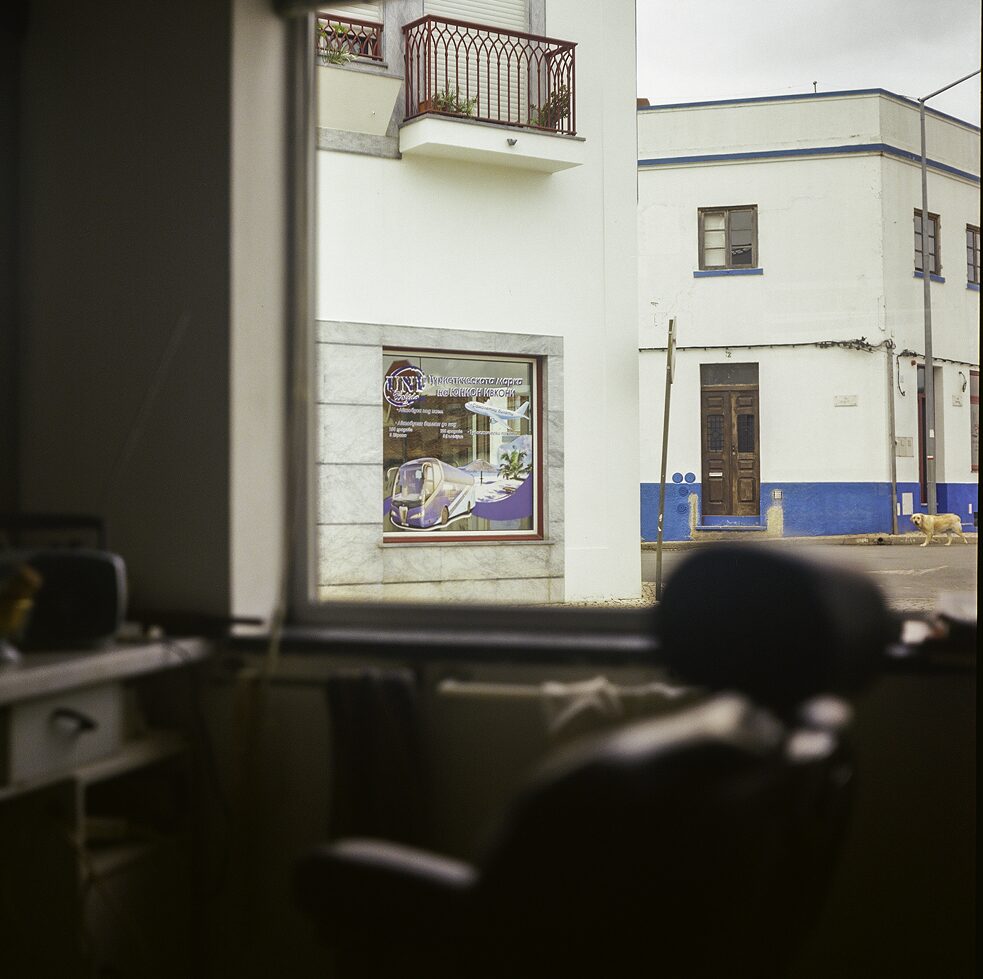 Blick aus dem Ladenfenster auf ein Reisebüro gegenüber.