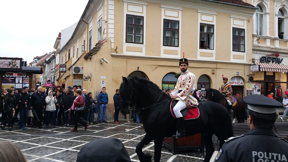 Ein Bursche auf einem Pferd, noch einer und ein Polizist in der Brașover Altstadt.