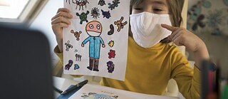 Coronavirus – Kind beim Online-Unterricht mit Schutzmaske