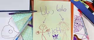 A picture painted by a child shows words in different languages.