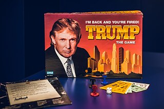 Trump: The Game / 1989-1990; 2004 Inspired by Donald Trump’s real estate business, this game is about buying and selling real estate. It was described as a boring and complicated variation of the popular game Monopoly, though Trump himself said it was »much more sophisti- cated than Monopoly.« Most people who bought the game probably did not bother reading the ten pages of instructions. The game was relaunched in 2004, following Trump’s success with the television series The Apprentice. It flopped, despite simplified game rules, and even more pictures of Trump. According to one review of the game, »It is not a game you want to play again.« 