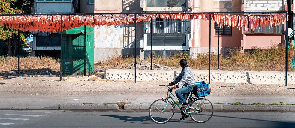 Ein Mann fährt mit seinem Fahrrad durch Stolipinovo, Plovdiv