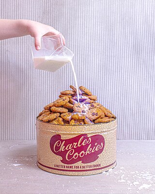 Ruth Wakefield n’a reçu qu’un dollar de Nestlé pour sa célèbre recette de biscuits au chocolat. Mais reprenons plutôt du début : Wakefield a inventé cette recette à la fin des années 1930 alors qu’elle dirigeait avec son mari Keith le populaire restaurant Toll House à Whitman, dans le Massachusetts. Elle n’avait plus de noix pour le biscuit qu’elle servait habituellement avec la crème glacée, et a ajouté à la place un peu de chocolat doux-amer grossièrement haché de Nestlé. Voilà : Le biscuit aux pépites de chocolat est né ! Et c’était aussi le moment idéal pour son invention, car le biscuit aux pépites de chocolat est devenu l’antidote parfait à la Grande Dépression !