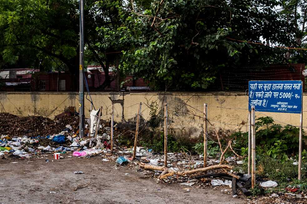 Aged yellow walls and rusty blue boards: this pale combination often adorns the perimeter of small public centres. Surrounded by trash and ignorance, the highlight of this nonsensical strategy is a warning to passersby of a penalty for littering – without any cameras or means to catch the offender.