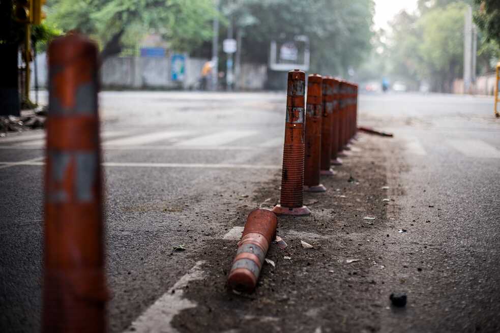 Temporary posts are left to stay longer than they should be here. These soldiers apparently serve a decorative purpose, as they are often run over by hastened drivers. Impressively, their roots remain intact.