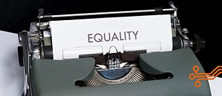 Das Bild zeigt eine Schreibmaschine mit einem Blatt Papier, auf das Equality, das englische Wort für Gleichberechtigung, getippt worden ist.