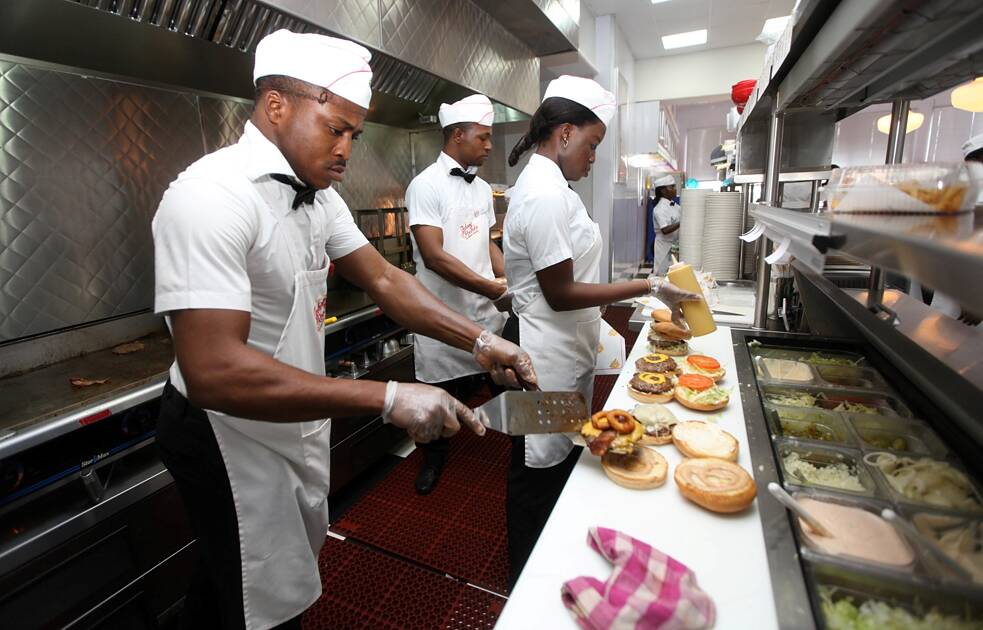 Nesta foto tirada na quarta-feira, 23 de janeiro de 2013, funcionários preparam hambúrgueres no restaurante Johnny Rockets, em Lagos, Nigéria. À medida que a classe média da Nigéria cresce, aumenta junto com ela o apetite por marcas estrangeiras na nação mais populosa da África, trazendo para o país mais restaurantes de fora do país, bem como mais empresas difusoras de um certo estilo de vida.