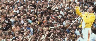 Wenn ihr es denn unbedingt so haben wollt: Freddie Mercury griff die fälschliche Erweiterung von „We are the Champions“ auf und schmetterte bei Liveauftritten gemeinsam mit den Fans zum Abschluss ein „..of the world!“