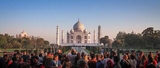 Tourist*innen in Indien fotografieren das Taj Mahal.