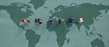 Geschäftsleute laufen in einer Reihe über eine Weltkarte