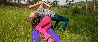 Drei Leute liegen auf einer Wiese