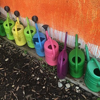 Le Rosengarten est situé directement au bord de l'Isar dans le quartier de Giesing à Munich. Dans la partie arrière du parc, plusieurs habitant.e.s de Munich se partagent un jardin, chacun.e cultivant un petit lopin de terre. Tout comme le jardin et le quartier de Giesing, les arrosoirs sont colorés.