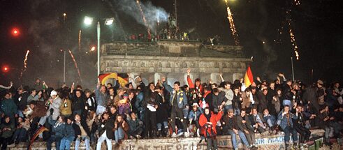1989年底，數十萬東西德人在勃蘭登堡門的柏林牆上慶祝新年。