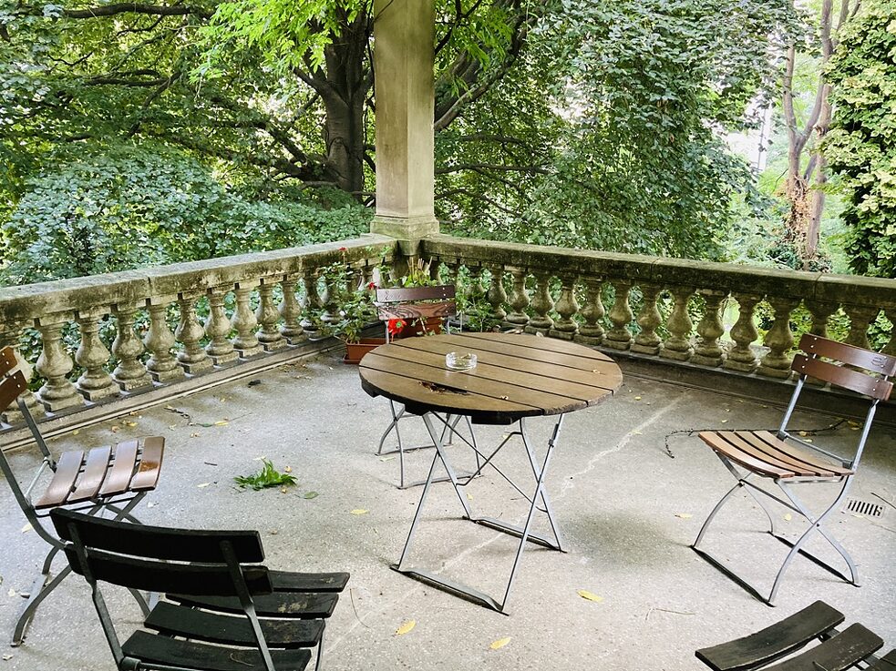 La terrazza all'ombra delle grandi piante del giardino