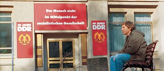 Ein junger Mann sitzt auf der Bank