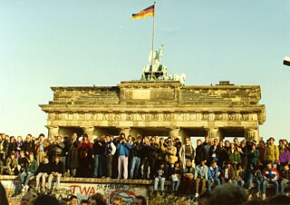 Locals celebrate on top of the opened Berlin Wall in 1989