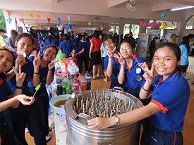 Schülerinnen mit einer einfachen Eismaschine, die für alle aus Cola, Fanta & Co. Wassereis gemacht hat