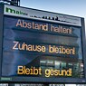 Ein Schild an der Straße, die am Messegelände vorbei in die Stadt führt, rät am Morgen "Abstand halten! Zuhause bleiben! Bleibt gesund!"