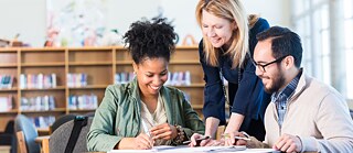 Erwachsene Lerngruppe arbeitet in einer großen Bibliothek