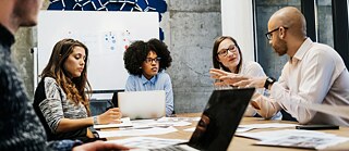 Zwei Männer und drei Frauen bei einer Besprechung