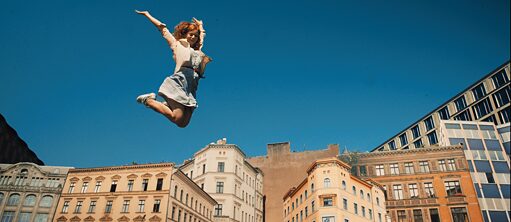 Cleo, Deutsches Filmfestival Neuseeland: eine junge Frau springt vor Häusern in die Luft