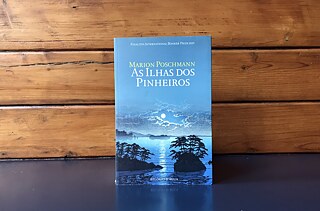 <b>As ilhas dos pinheiros, de Marion Poschmann</b><br>Relógio D’Água, 2019. Tradução de Paulo Rêgo<br><br>Finalista em 2019 do Prémio Internacional Man Booker e em 2017 do Prémio do Livro Alemão, <i>As Ilhas dos Pinheiros</i> (Die Kieferninseln), de Marion Poschmann leva-nos ao Japão, o país do chá, pela realidade (ou será sonho?) de Gilbert, um investigador de barbas que sonha estar a ser traído pela mulher, e que durante a viagem de avião decide seguir o “caminho” do poeta japonês Basho (um eremita viajante) até às ilhas dos pinheiros, procurando através da concentração na natureza resolver o conflito interno resultante da possível traição.
