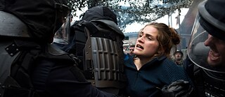 Noor naine võitleb demonstratisooni ajal märulipolitseiga