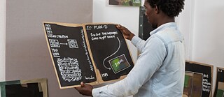 Resident Elmuontasir Elhassan mit Arbeiten seines Projekt 'Rearranging the Camouflage' | Foto: Goethe-Institut Sudan/Abdalsalam Alhaj