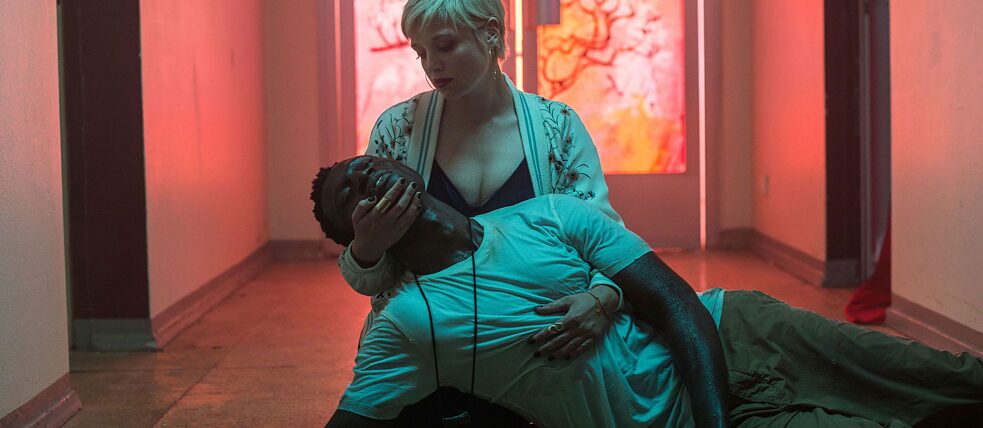 Naine istub põrandal, mees on põrandal pikali, pea naise süles