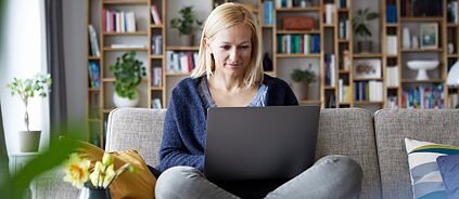 Online Kurs - Eine Frau arbeitet zu Hause am Laptop