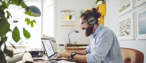 Kulaklık ve dizüstü bilgisayar ile genç adam