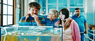 Drei Personen vor dem Aquarium