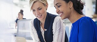 Zwei Frauen arbeiten gemeinsam an einem Laptop