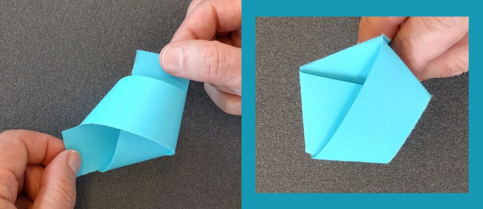 Iš šviesiai mėlyno popieriaus juostelės išlankstytas penkiakampis