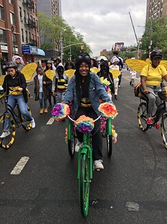 Ein Mädchen verkleidet als Biene auf einem Fahrrad.