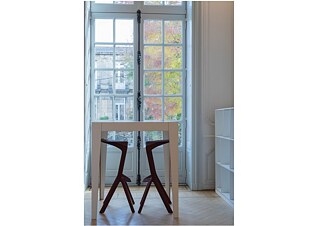 2 tabourets et une table devant une grande fenêtre
