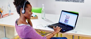 Lernende mit modernen Medien - Frau zu Hause mit Laptop