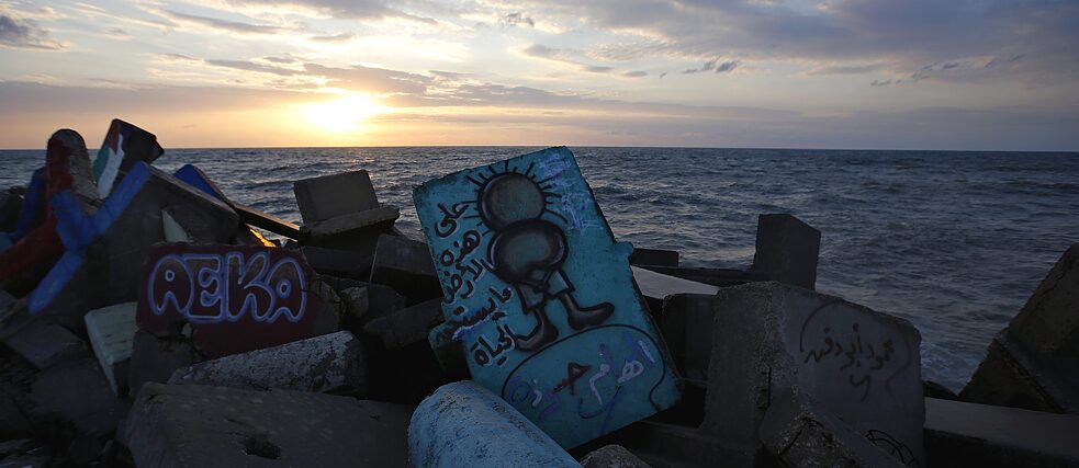 Dekolonisierung – Ein Bild der Cartoon-Figur Handala ist auf einem Felsen des Gaza-Hafens bei Sonnenuntergang zu sehen,