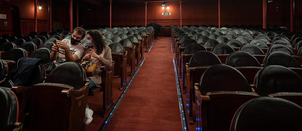 Zuschauer und Zuschauerin mit Mund-Nasen-Schutz allein im Saal Cándido Lara des Teatro Lara in Madrid.
