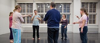 Henkilöitä seisoo ringissä.