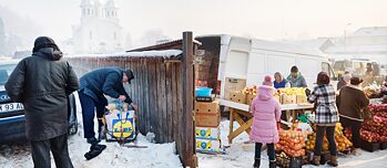 Menschen sammeln sich vor Marktstand mitten im Winter