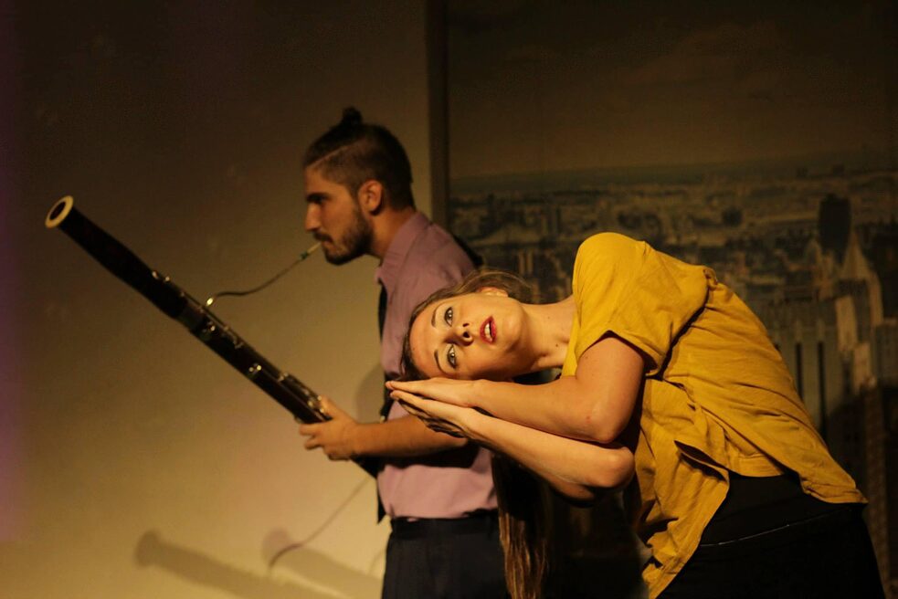 Performance mit Frau und Mann, der im Hintergrund Fagott spielt