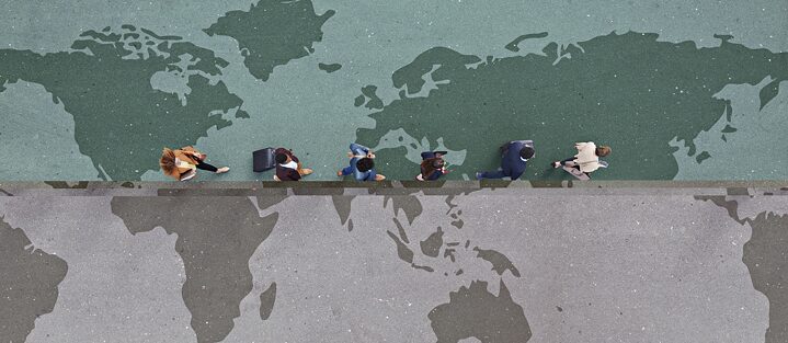 Bird's eye view: 6 people walking in a row across a floor with a map of the world