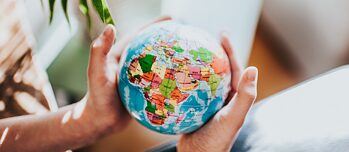 Two hands holding a globe 