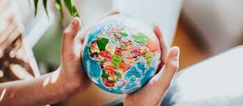 Two hands holding a globe 